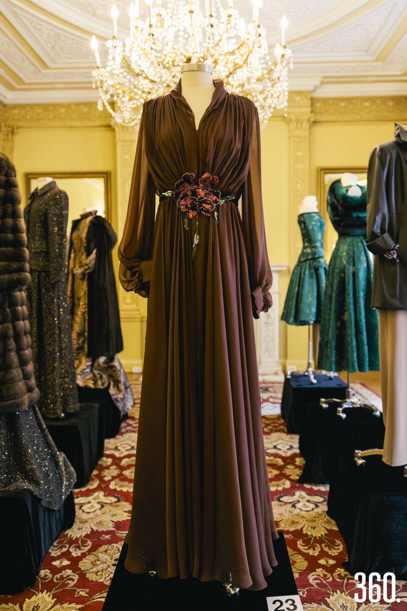 $!Vestido fluido en tono chocolate con acento floral, evocando elegancia y feminidad contemporánea.