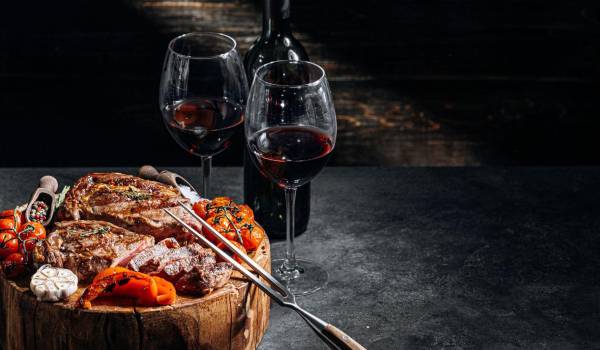 Un filete jugoso y dos copas de vino argentino: el maridaje perfecto que celebra la pasión de la tierra y la vid.