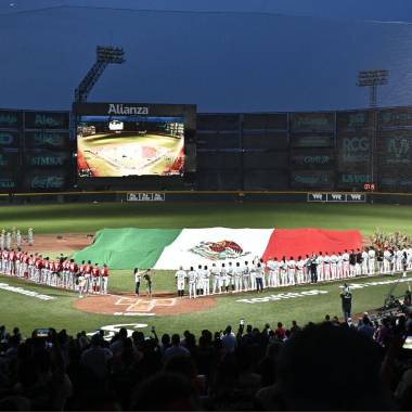 Un momento emotivo previo al arranque del partido, ambos equipos, frente a la bandera.