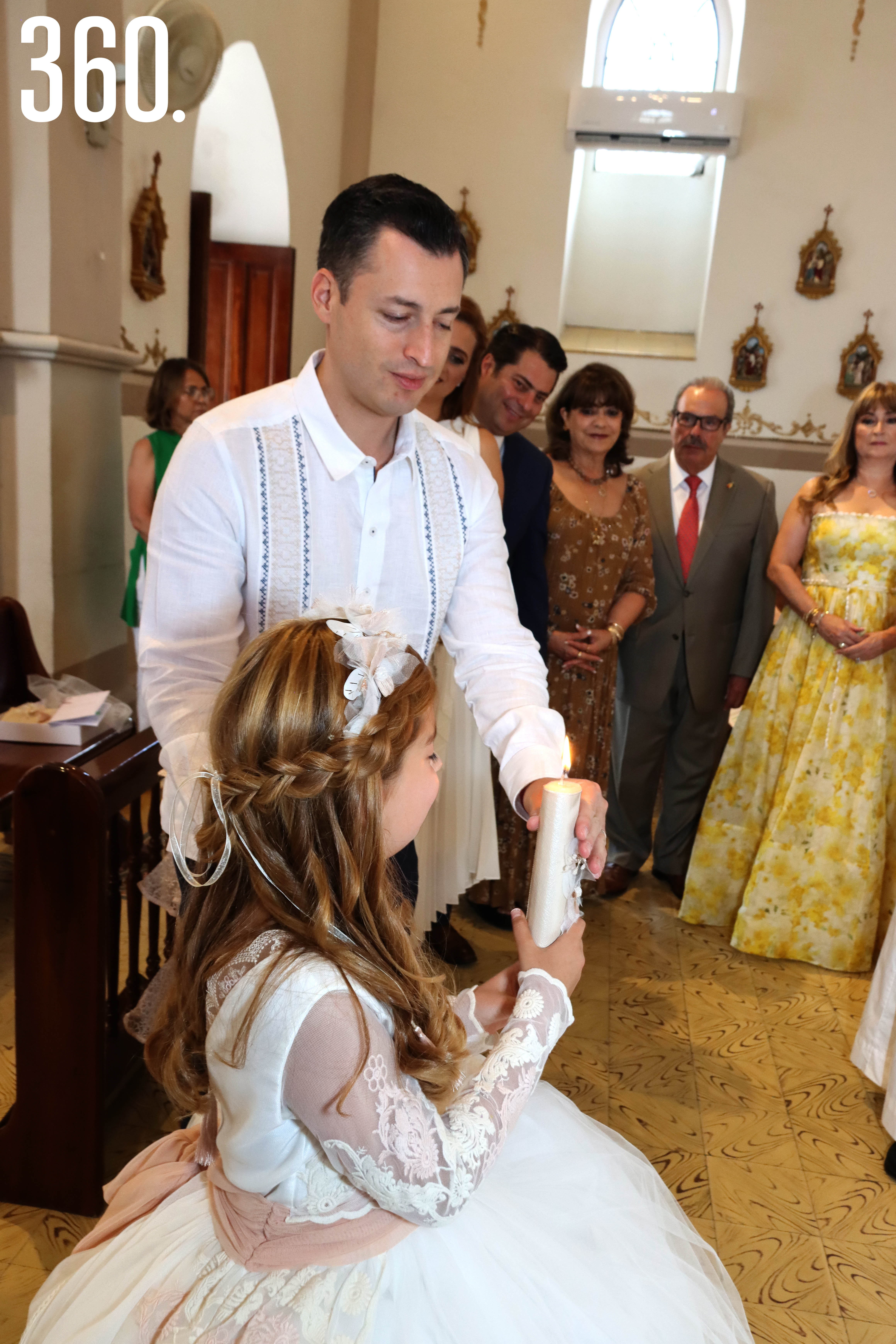 Luis Donaldo Colosio Riojas entrega la Luz de Cristo a su ahijada Lilia María Martínez Hiarmes durante la “Ceremonia de la Luz”.